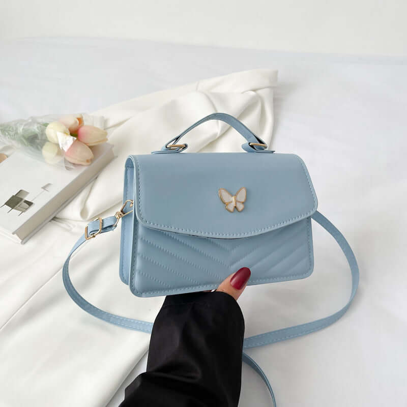 Light blue Simple Crossbody Bag with top handle flap closure gold butterfly detail and adjustable strap