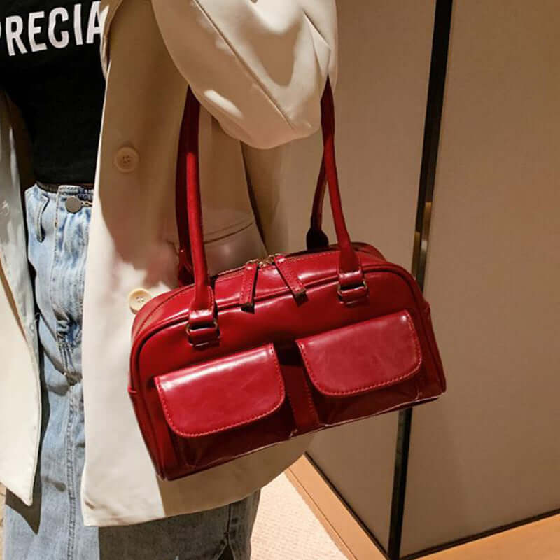 Red stylish work handbag for women with dual front pockets and long handles carried by a woman
