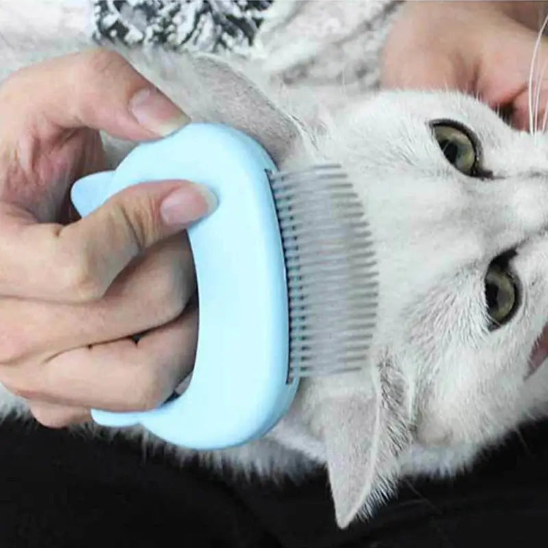 A close-up of the Cat Grooming & Massage Comb in use, with a person grooming a cat's head, demonstrating its ergonomic design. #cats