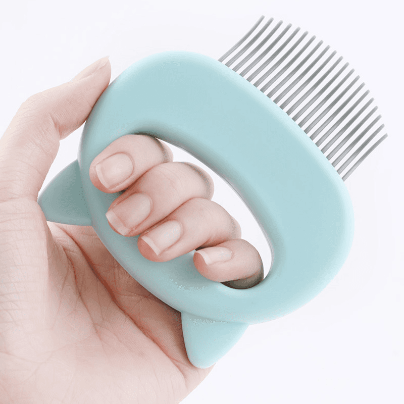 A hand holding the Cat Grooming & Massage Comb, showcasing its comfortable grip, perfect for grooming cats. #cats