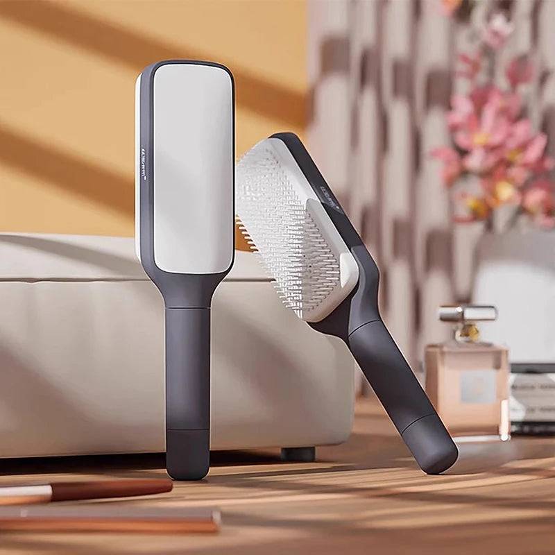 Self-Cleaning Brush by CozyTech Living in a chic environment, showcasing the sleek dark design of the brush next to a decorative item.