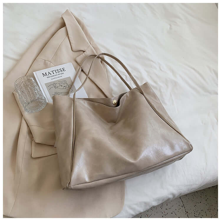 Fashion Handbag New Autumn And Winter Japanese And Korean Large Capacity Soft Leather Shoulder Bag in soft beige color next to fashion accessories.