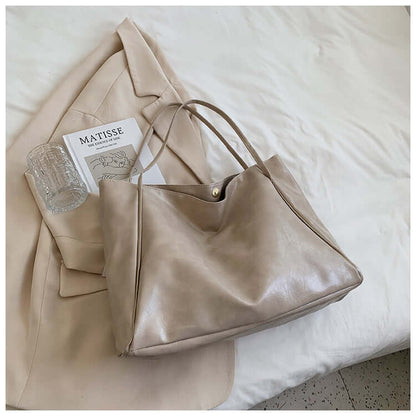 Fashion Handbag New Autumn And Winter Japanese And Korean Large Capacity Soft Leather Shoulder Bag in soft beige color next to fashion accessories.