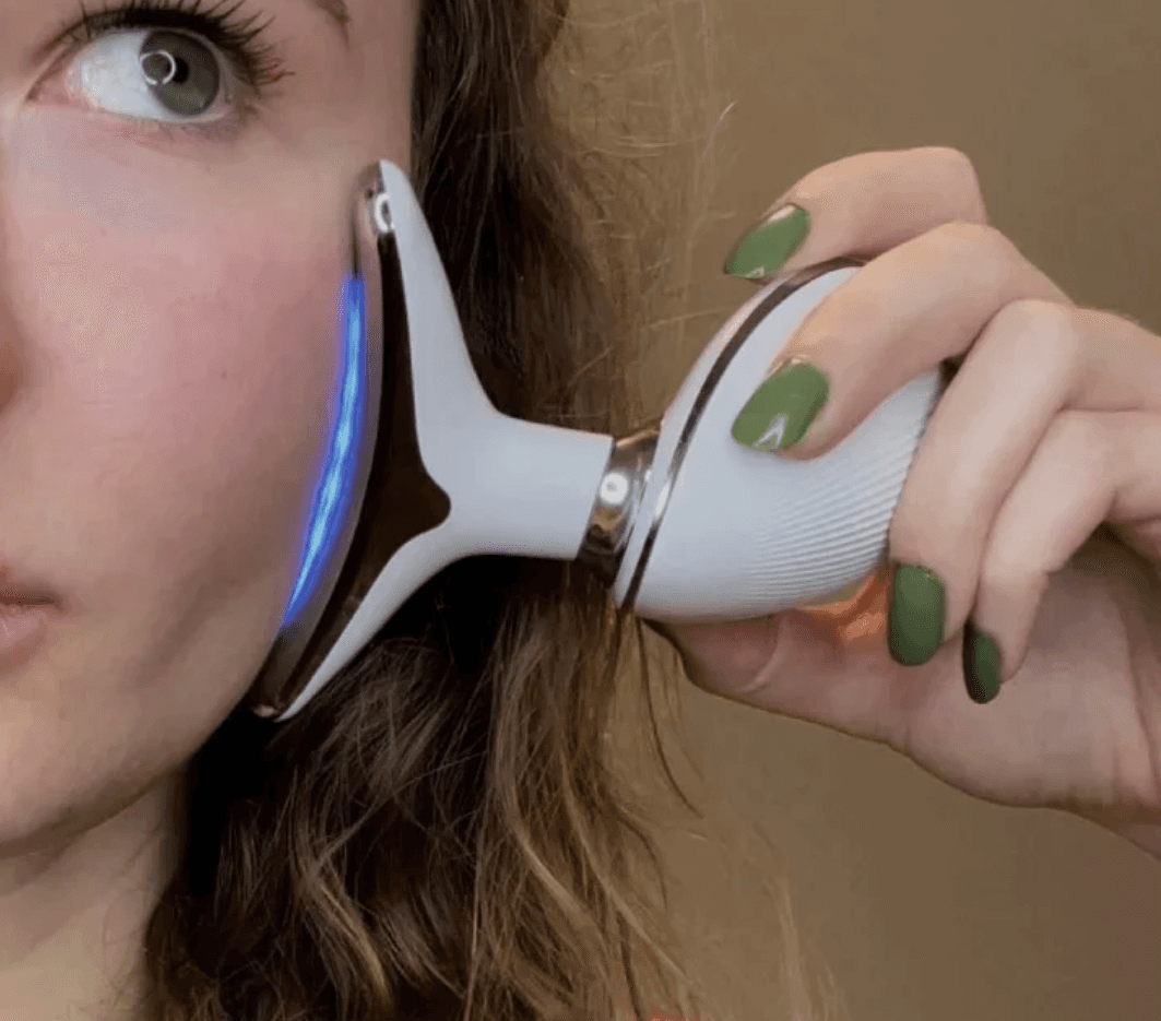 A close-up view of the Pure Aura Micro Glow Massager being used on a woman's face, demonstrating its skin rejuvenation capabilities and blue light feature, essential for a radiant appearance. Found in the lumiglow, lumiglow pro range.