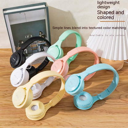 Foldable Bluetooth Headset in six vibrant colors on a wooden surface demonstrating lightweight design.