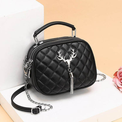 Black quilted one shoulder handbags for women with silver deer emblem and tassel detail