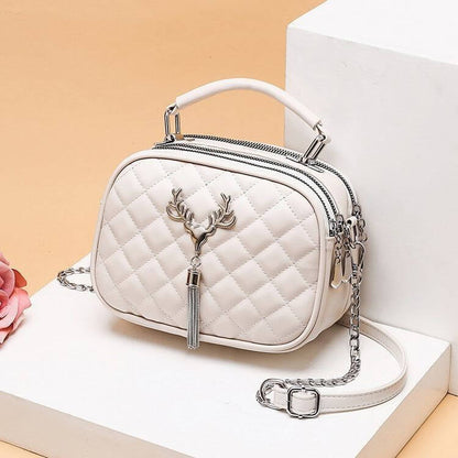 White quilted one shoulder handbags for women with deer emblem and silver chain strap