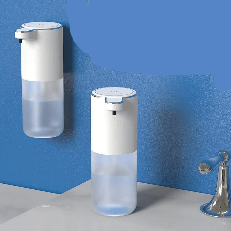 Wall mounted and desktop touchless soap dispenser in white with transparent soap container on blue wall background