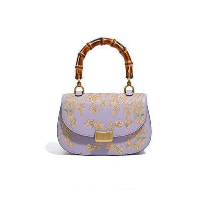 Stylish Cowhide Leather Handbag with Exquisite Embroidery and Bamboo Handles for Women - Front view of a lavender cowhide leather handbag adorned with exquisite embroidery and a bamboo handle.