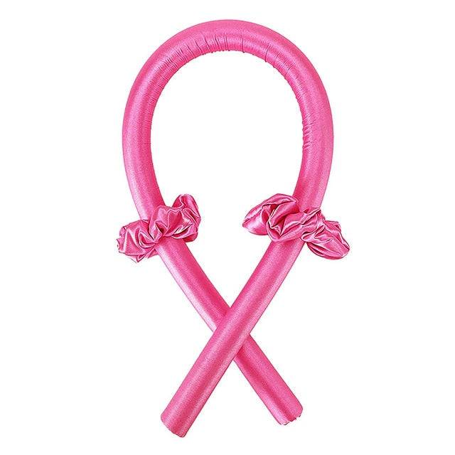 A vibrant pink Heatless Curling Rod Headband designed for effortless styling, shown with scrunchies. This innovative hair styler allows for beautiful curls without heat exposure. Tags: beauty, curler, hair styler.