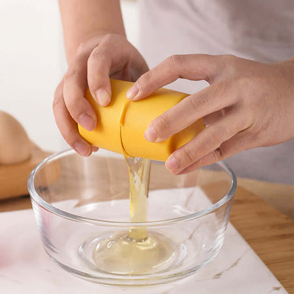 Hands using eprolo easy egg cracking device to crack an egg into a clear glass bowl