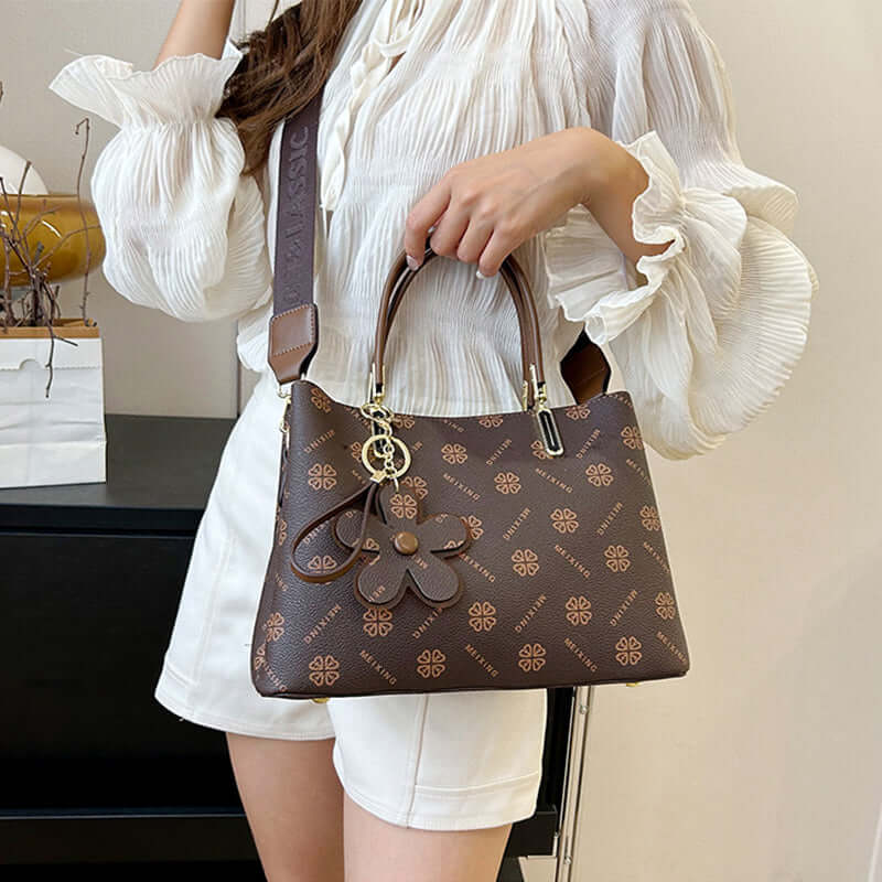 Woman holding fashion printed tote bag for women in brown with floral pattern and charm accessories