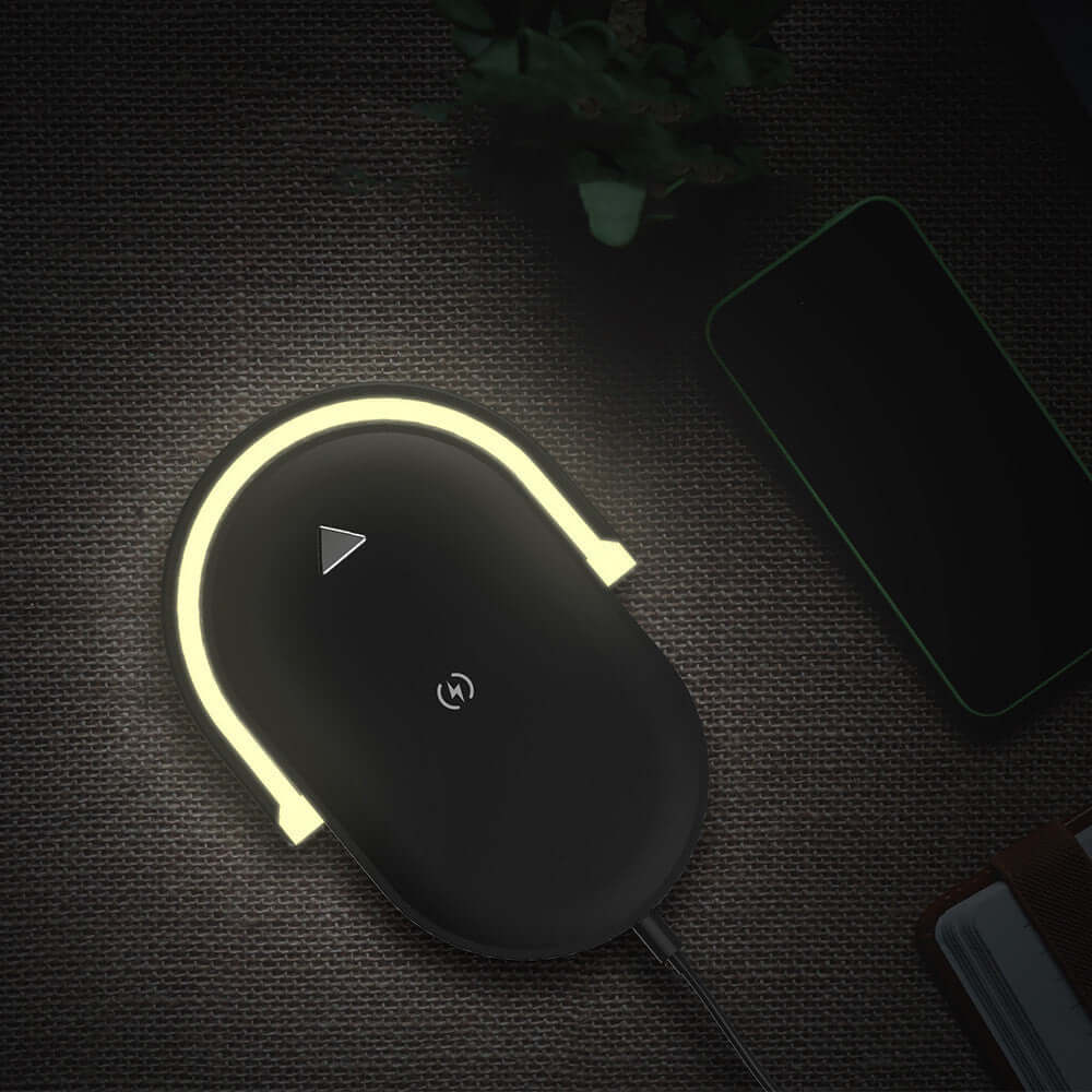 Dropshipman fast wireless charger with night light glowing on a dark surface next to a smartphone
