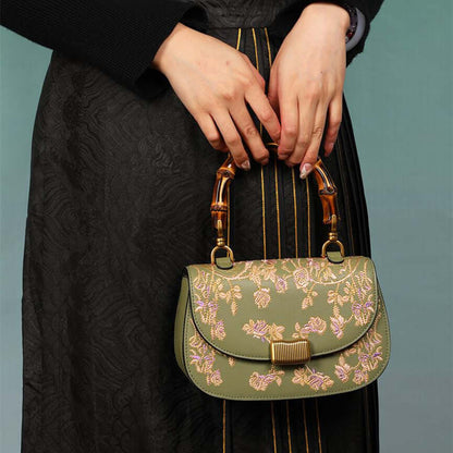 Stylish Cowhide Leather Handbag with Exquisite Embroidery and Bamboo Handles for Women - Model showcasing an olive green cowhide leather handbag with intricate embroidery and bamboo handles.