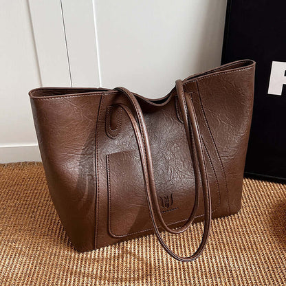 Casual Retro Shoulder Bag Texture Class Commuter Tote positioned on a decorative surface, highlighting the details of the medium soft tote bag in brown.