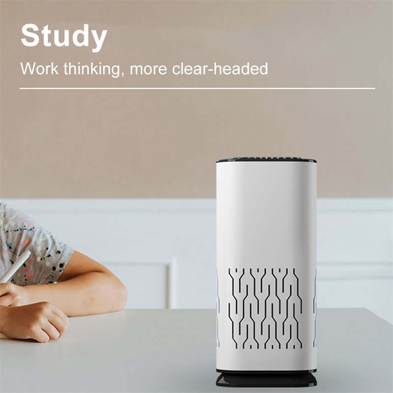 White portable car air freshener ionizer on desk next to person studying for clear-headed work
