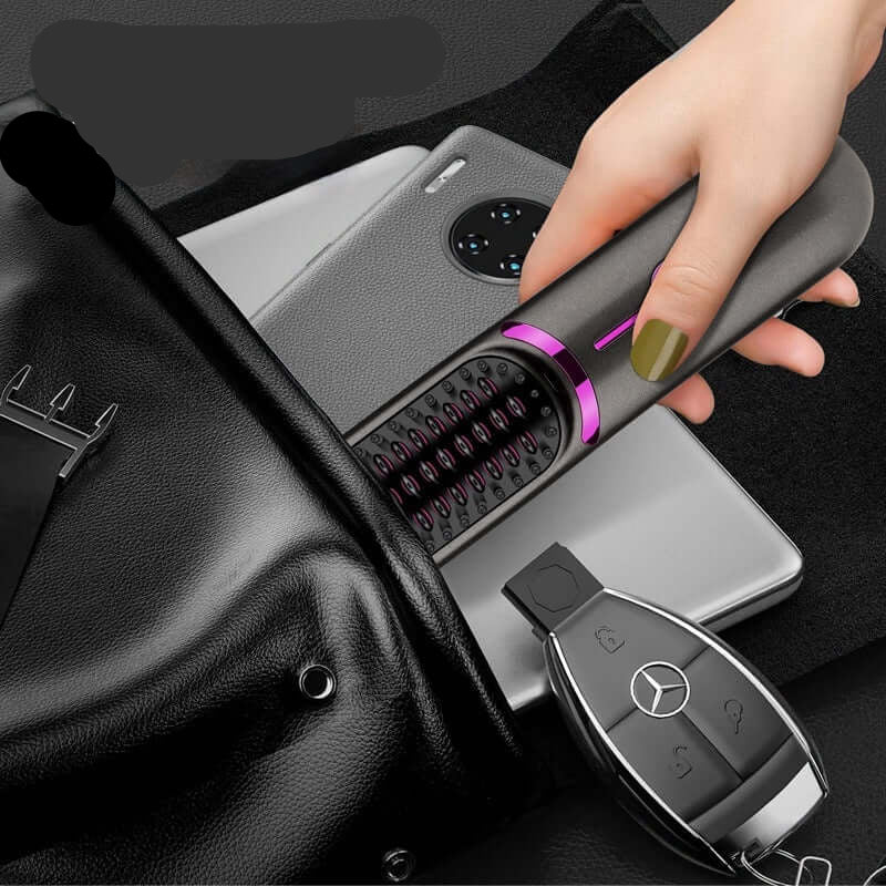 Hand placing portable USB charging hair straightener into black leather bag with phone and car keys