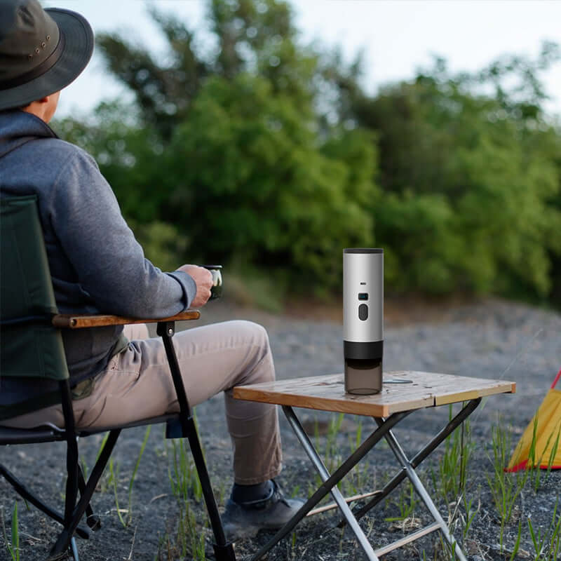 Adventurer relaxing outdoors with the Portable Espresso Maker with 7800mAh Battery, illustrating its portability for on-the-go brewing.