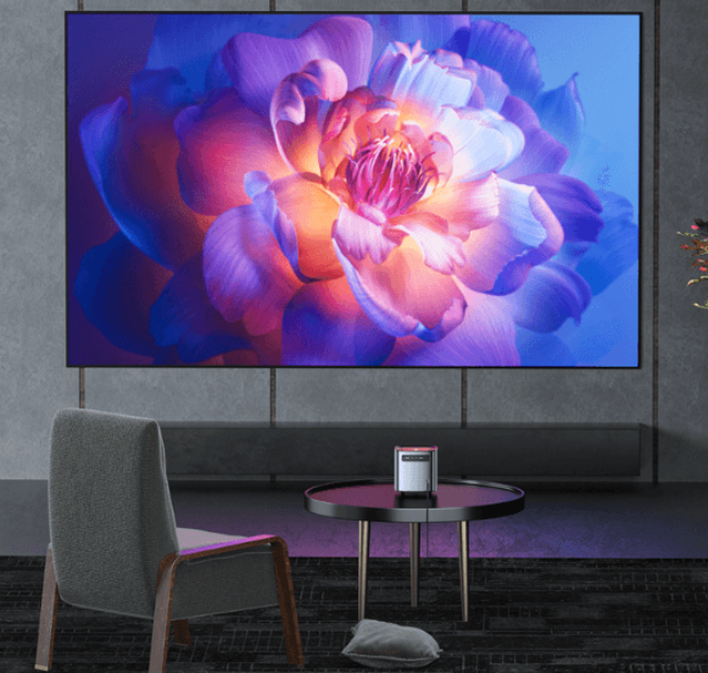 Smart projector for living room displaying a vibrant flower image on a large wall screen above a modern chair and table