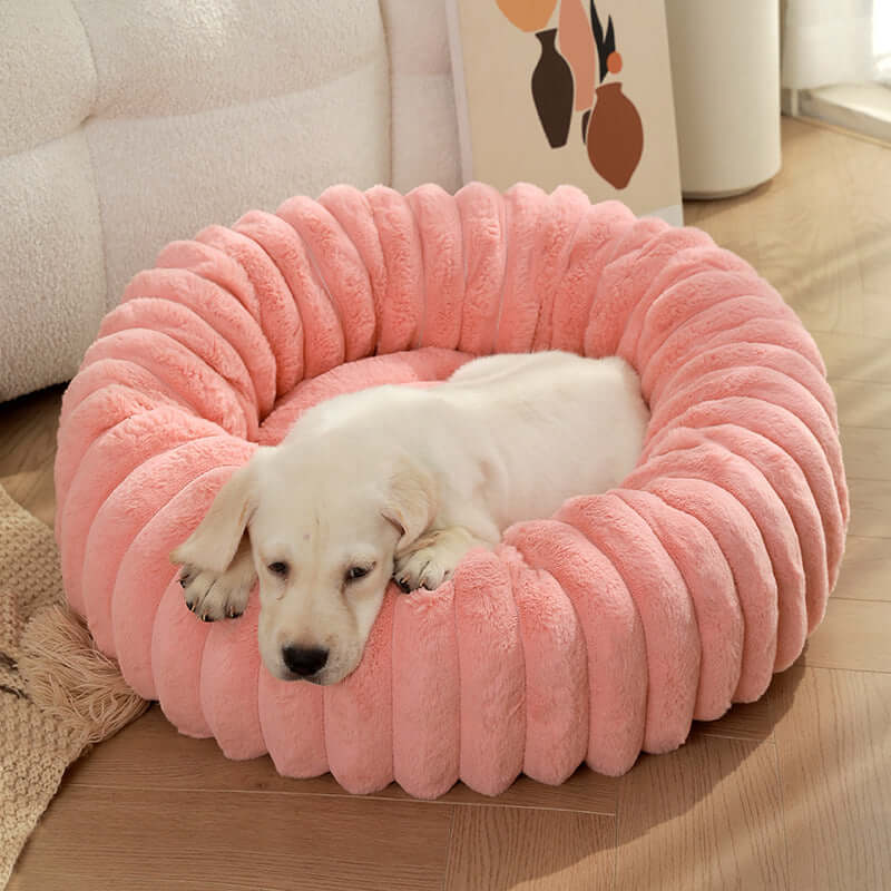 White puppy resting on a pink super soft pet sleeping mat in a cozy indoor setting