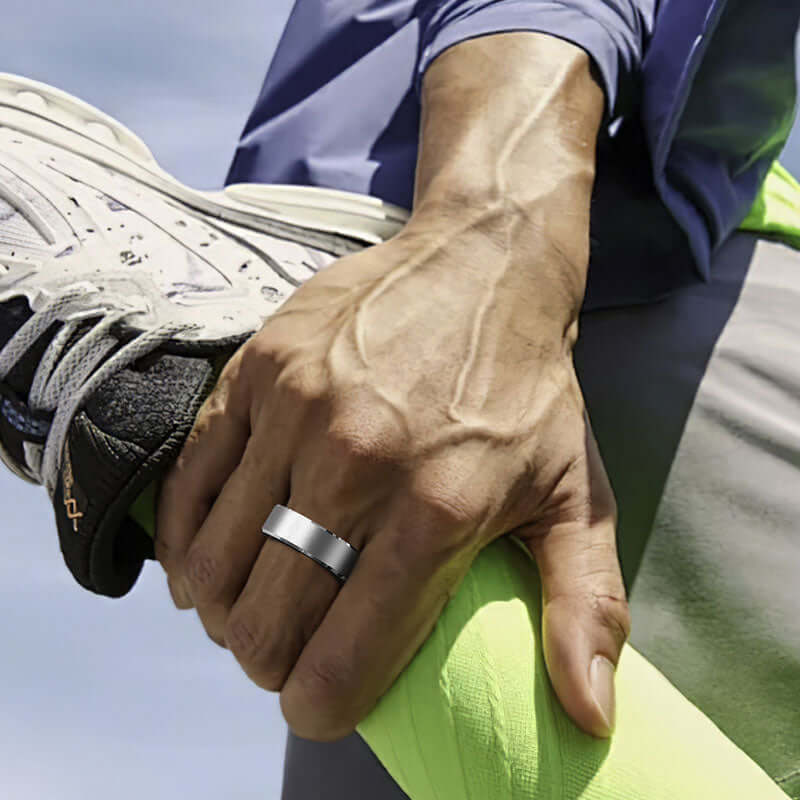Xiaomi smart ring fitness tracker worn on hand of athlete stretching leg outdoors